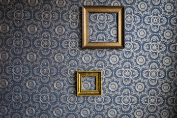 Old frame made of gypsum, on blue wallpaper