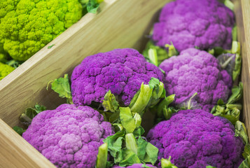 Fresh colorful vegetables on the counter of the store: purple cauliflower, Brussels sprouts