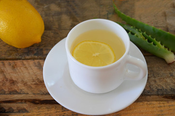 Drink with aloe vera and lemons. Glass cups on wooden background