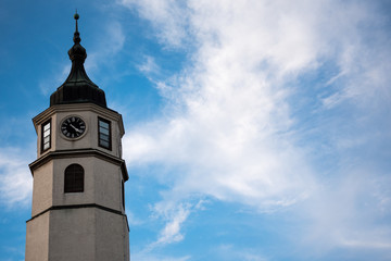 Fototapeta na wymiar Tower with watch and blue sky in background