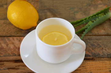 Drink with aloe vera and lemons. Glass cups on wooden background