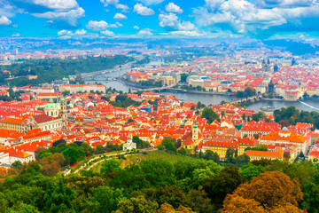 Fototapeta na wymiar Beautiful panorama of Prague from the top of the Petrin gardens in Prague, Czech Republic. Red tiled roofs of Prague and bridges on the Vltava