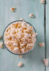 salty popcorn on turquoise wooden surface