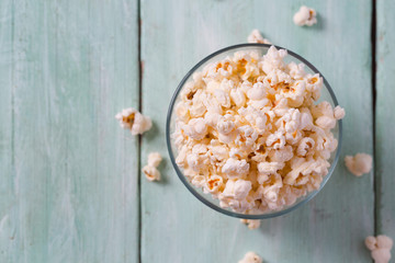 salty popcorn on turquoise wooden surface