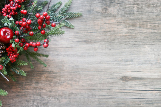 Christmas Evergreen Branches and Berries in Corner Over Rustic Wooden Background