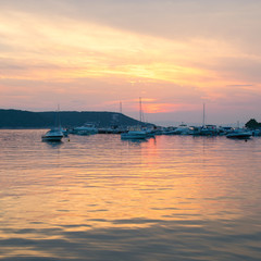 The fiery sunset reflects on the sea of  the marina.