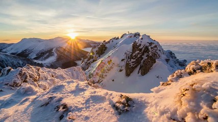 Colorful golden sunset in snowy mountains in winter above mist clouds. Dolly shot time lapse day to night
 - Powered by Adobe