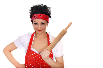 Aggressive smiling housewife with a rolling pin in the hand