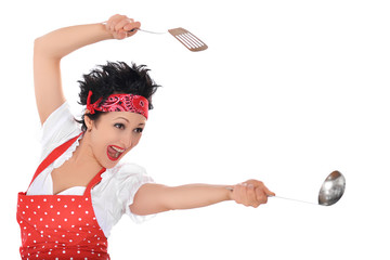 Crazy tousled housewife fighting with kitchenware