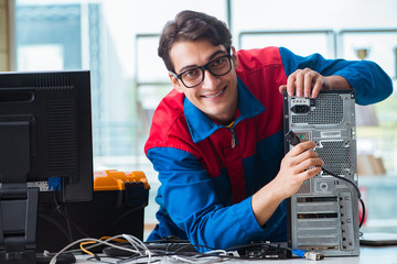 Computer repairman working on repairing computer in IT workshop