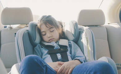 little girl sleeping peacefully in carseat, filtered tones