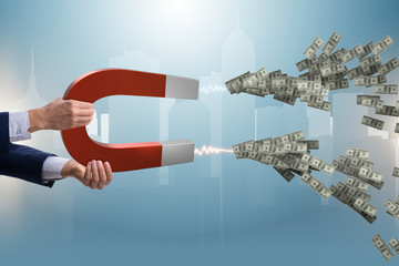 Businessman catching dollars on horseshoe magnet