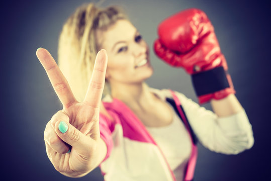 Woman wearing boxing gloves showing peace