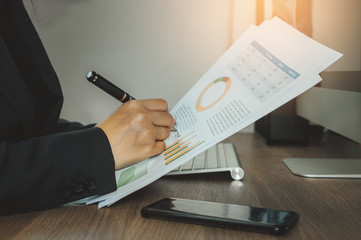 Business woman reading and checking documentation on her working space