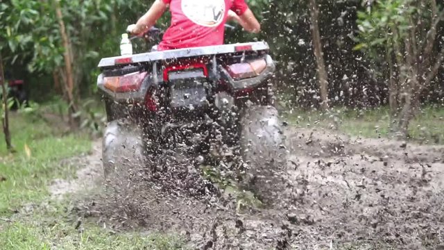 ATV skiding on dity road in forest