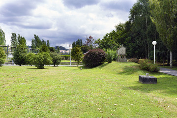 Fototapeta na wymiar Garden with well-kept lawn and trees with cloudy sky. Park of the brothers Naveira in Betanzos, Galicia, Spain