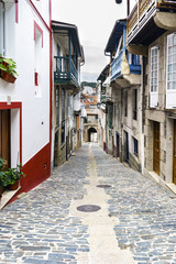 Fototapeta na wymiar Typical street of a village of galicia on slope and finished in an arch with the stone floor and old houses in a village called Betanzos in Galicia, Spain
