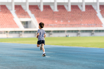 Fototapeta premium Boy running on the blue track