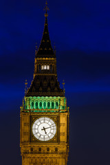 Fototapeta na wymiar The clock of the Elizabeth tower also known as Big Ben at dusk with a beautiful blue sky as a background, Houses of Parliament, London, England