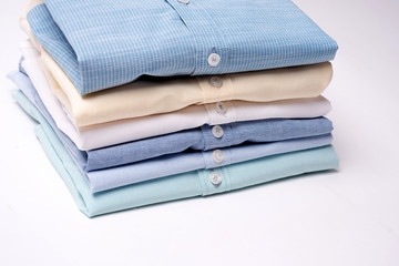 Classic men's shirts stacked on white background.