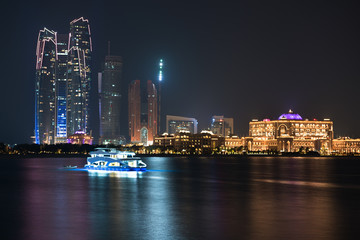 Fototapeta premium Abu Dhabi buildings skyline from the sea at night