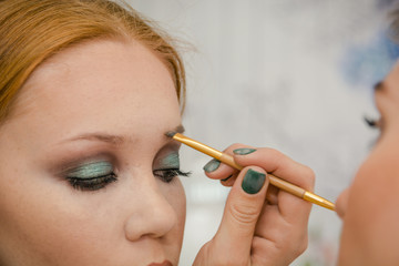 The girl makes up eyes in salon. Face care in salon.