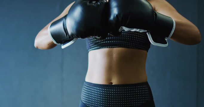 Attractive female boxer getting ready to train putting on gloves