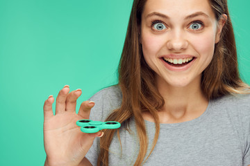 Beautiful young woman on a green background holds a spinner