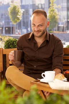 Handsome man drinking coffee outdoors