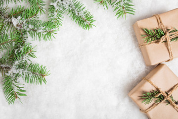 Snowy fir branches and gifts on snow. Christmas and New Year background with copy space.