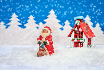 Beautiful Christmas card with a Santa and a house in the winter forest in the snow