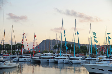 The bay with yachts is surrounded by low hills. Sunset over the bay. Harbor with yachts in Barcelona. Marina for yachts in the Mediterranean.