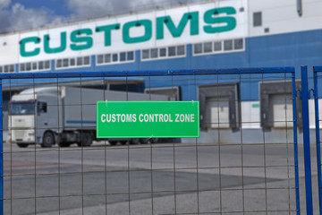Customs control space with truck near warehouse storage of goods.