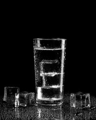 Water with ice and drops of water on a black background