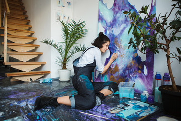 Girl mixes paints in palette, going to start arts therapy