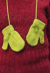 Winter green gloves on wool sweater