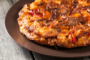 Tortilla de patatas. Spanish omelette with sausage chorizo, potatoes, paprika and egg, accompanied by olive oil
