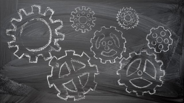 Gears mechanism chalk drawings animation at the blackboard as teamwork concept.