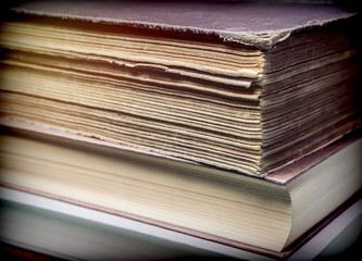 Several old books with pages worn stacked, conceptual image