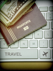 Some tickets of dollar above a passport on a keyboard, conceptual image