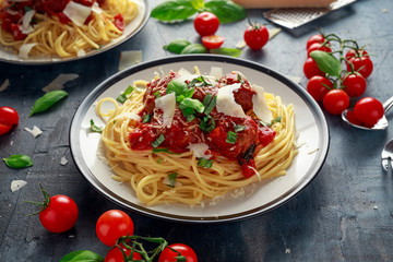 Spaghetti pasta meatballs with tomato sauce, basil, herbs parmesan cheese on dark background