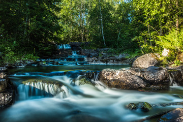 Fototapeta premium A beautiful river with small watefalls and bridge