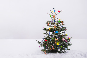 curious open air christmas tree in the snow decorated with sausages, balloons, toilet brushes and clothespins - 181331791