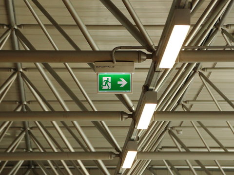 Green Exit Sign under Grid Roof with Lamps
