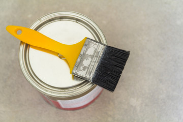 House renovation. Can with paint and a brush tool on concrete background