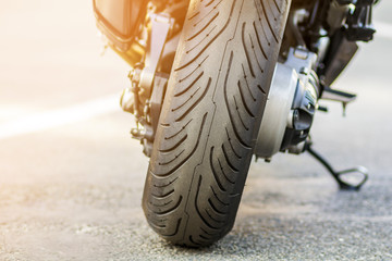 Rear wheel of sports motorcycle on road. Motorbike parked on a street. Freedom and travel concept.