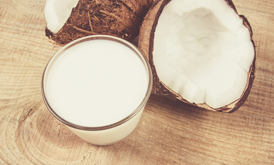Coconut with coconut milk on wooden background.
