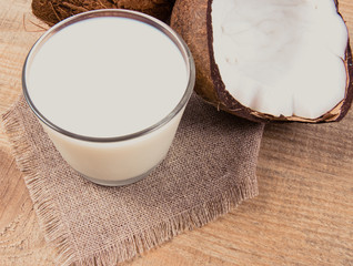 Coconut with coconut milk on wooden background.
