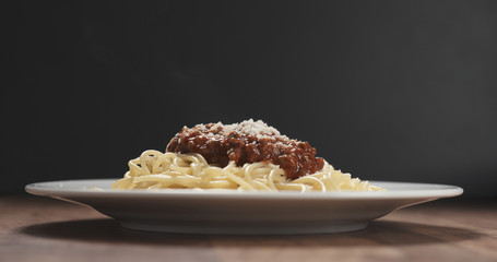 classic spaghetti bolognese with parmesan on plate on table
