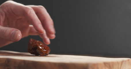 closeup man slicing sundried tomatoes